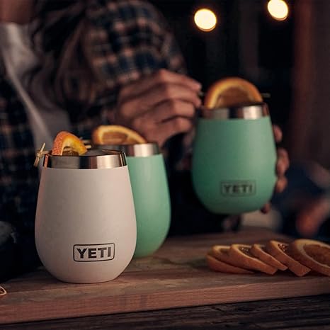 YETI insulated cups on a wooden surface with people in the background